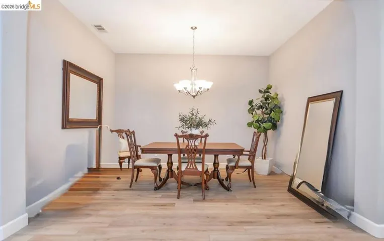 Dining area with light wood-style flooring and a chandelier