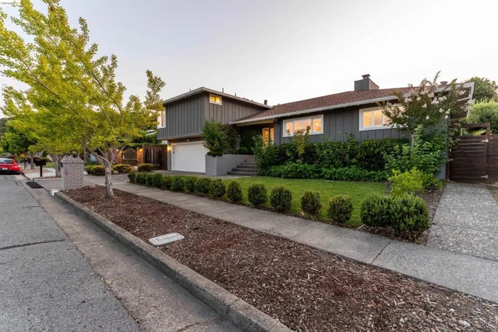 Split-level residence featuring a gray exterior with white trim