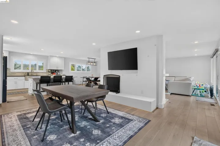 Spacious open-concept living area featuring light wood-finish flooring and recessed lighting
