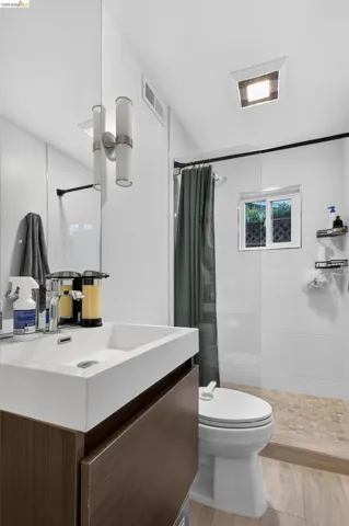 Modern bathroom with a wood-finish vanity, integrated rectangular sink, and chrome faucet