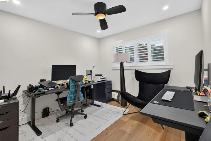 Room featuring a window with white louvered shutters, recessed lighting, and a ceiling fan with integrated lighting