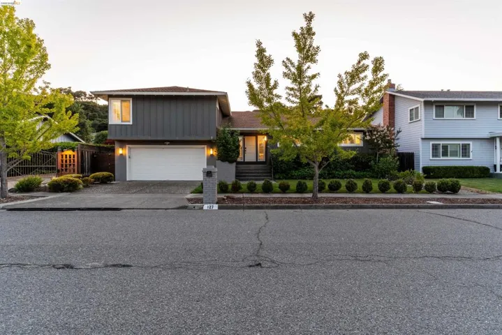 Split-level residence featuring a two-car garage and a paved driveway