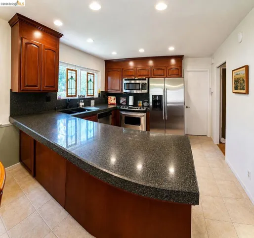 Curved peninsula countertop with dark speckled finish