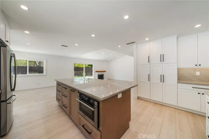 Beautiful light in the main living area. The white linen walls and pale flooring creates a great palette to work with. Looking from sink across the Great Room.  Lots of storage in this kitchen!