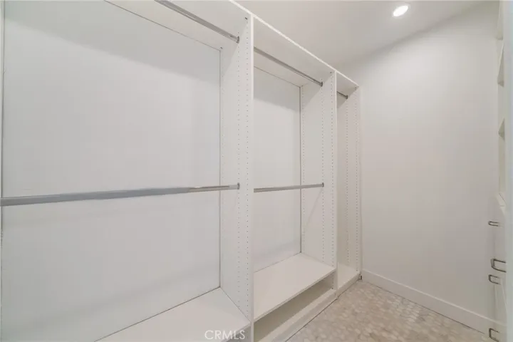 Primary closet has lots of hanging space plus shoe storage at bottom.