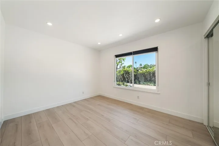 Bedroom 2 has large window and mirrored closet doors.
