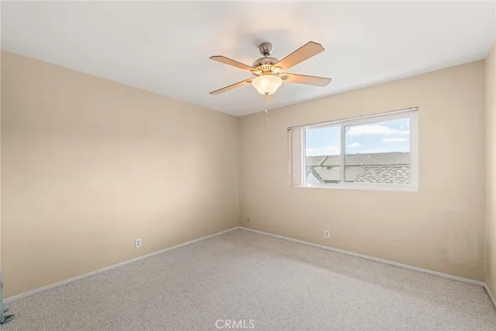 Guest bedroom with large window for natural light.