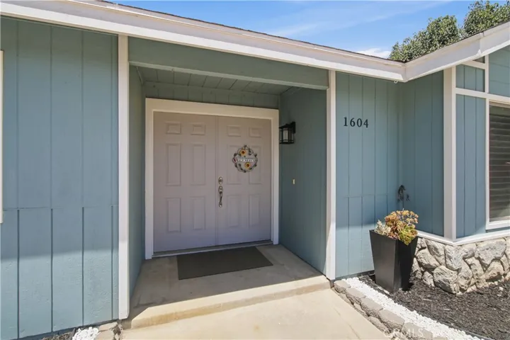 Blue ranch style home with double white frontn doors