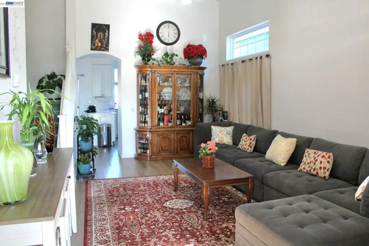 Vaulted ceilings and oversized windows fill this inviting living room with natural light. The open layout creates a spacious, comfortable setting ideal for gatherings or quiet evenings at home.