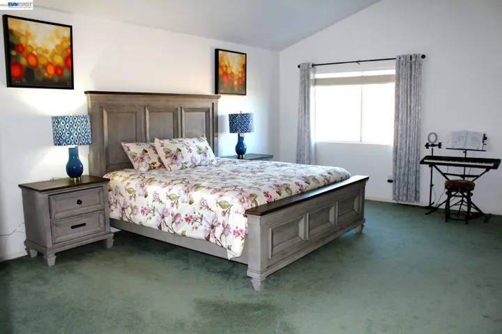 Spacious primary bedroom with oversized proportions, large windows, and plenty of room for a sitting area or workspace. A bright, relaxing retreat designed for everyday comfort.
