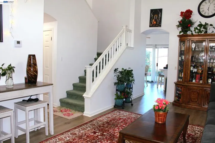 Elegant foyer with vaulted ceilings, an open staircase, and beautiful sightlines through the main living spaces. A bright, welcoming entrance that sets the tone for the rest of the home.