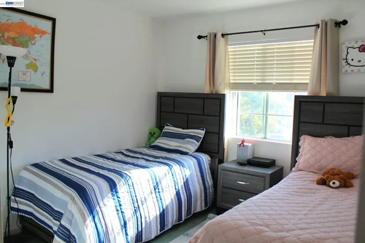 Comfortable third bedroom featuring large windows, natural light, and a functional layout. Perfect for children, guests, or a productive workspace