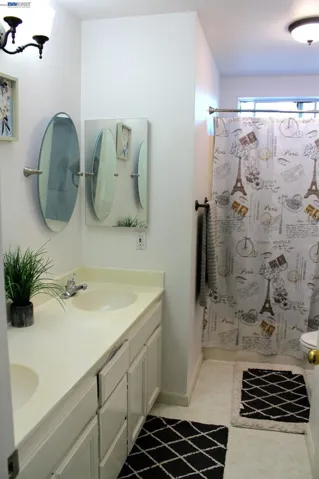 Well-appointed upstairs full bathroom featuring a dual-sink vanity, generous counter space, a shower-over-tub combination, and abundant natural light—designed to comfortably serve the secondary bedrooms and guests.