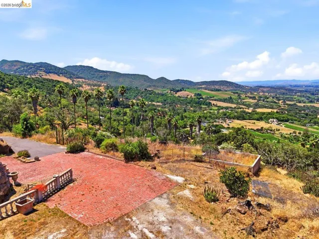 Aerial view of level paved area overlooking distant hills and agricultural terrain