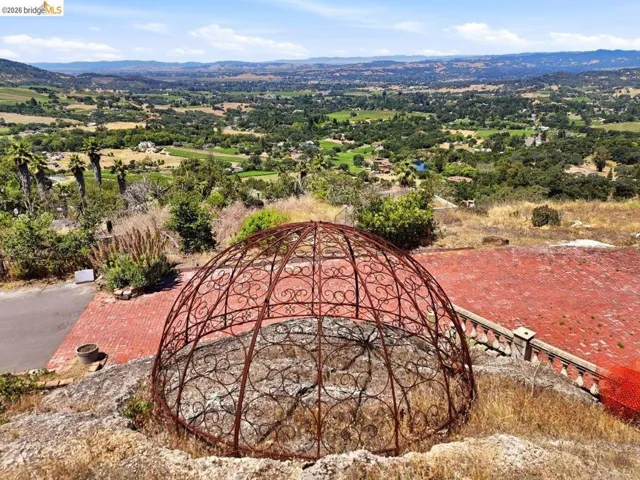 Wrought iron ornamental dome structure situated over the cave entrance with the Napa Valley view beyond.