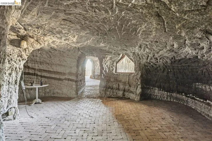 Cave features stone walls, floor and ceiling with some window openings