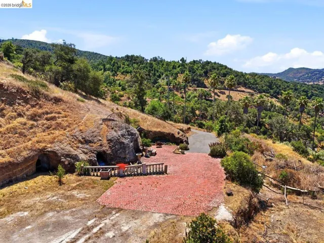 Aerial view featuring the level, paved area and entrance to the cave