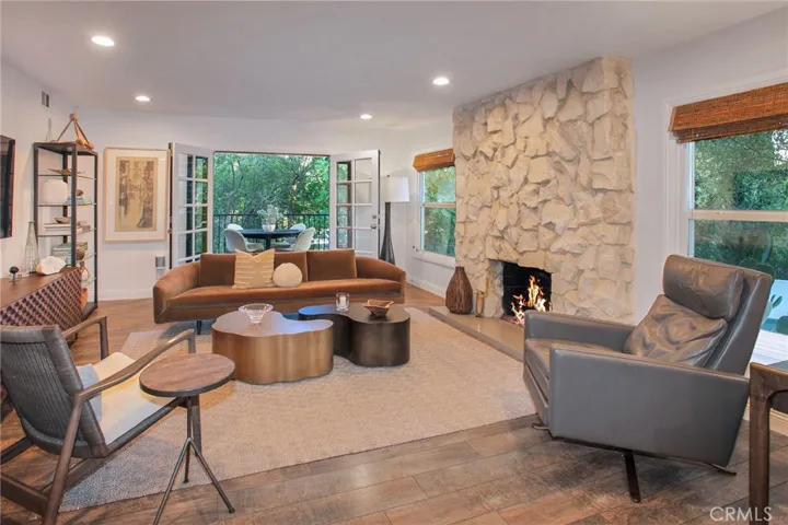 The living room is anchored by the striking fireplace with a designer insert, while French doors with sidelights open to an expansive deck, creating a seamless connection between the indoors and out.