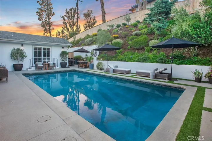 Multiple outdoor spaces, and the sparkling heated saltwater pool invite everything from lively weekend gatherings to quiet mornings with a cup of coffee. A gas fireplace, mature landscaping, newer smart-controlled pool equipment, and peaceful hillside surroundings provide inviting spaces to enjoy throughout the year.