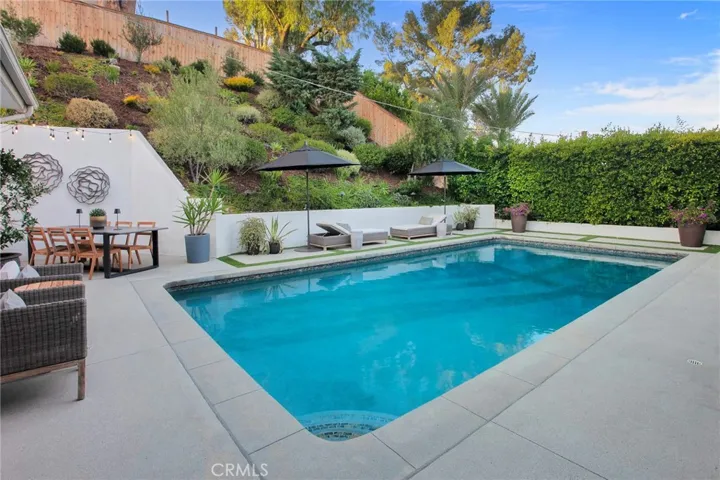 Multiple outdoor spaces, and the sparkling heated saltwater pool invite everything from lively weekend gatherings to quiet mornings with a cup of coffee. A gas fireplace, mature landscaping, newer smart-controlled pool equipment, and peaceful hillside surroundings provide inviting spaces to enjoy throughout the year.