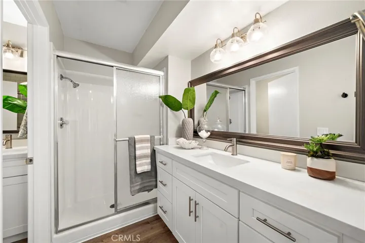 Private primary sweet bathroom with newer vanity, reglazed shower and new glass enclosure