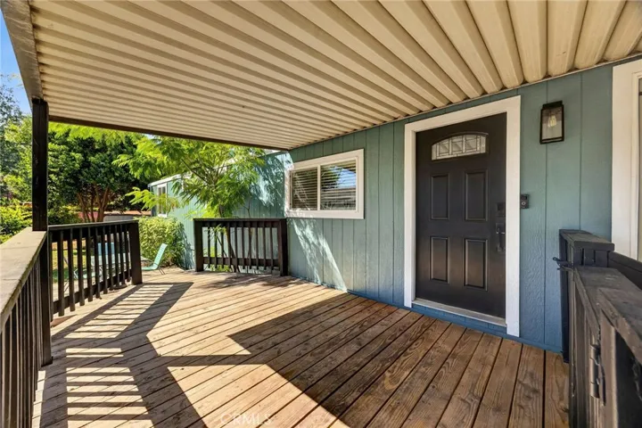 Large covered front deck steps down to a patio