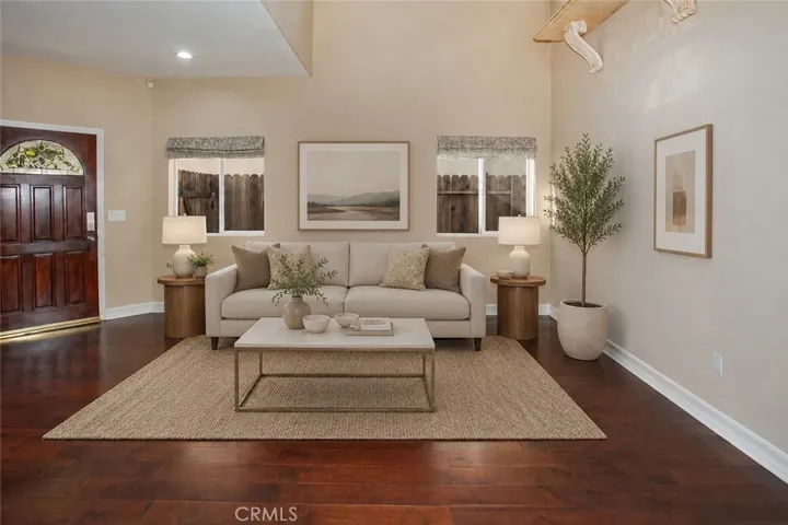 Photo is virtually staged.  Previous photo is how property currently shows. The formal living room offers a warm welcome for guests, while the adjacent dining room, highlighted by its elegant double tray ceiling, is equally suited for holiday celebrations, dinner parties, or everyday meals.