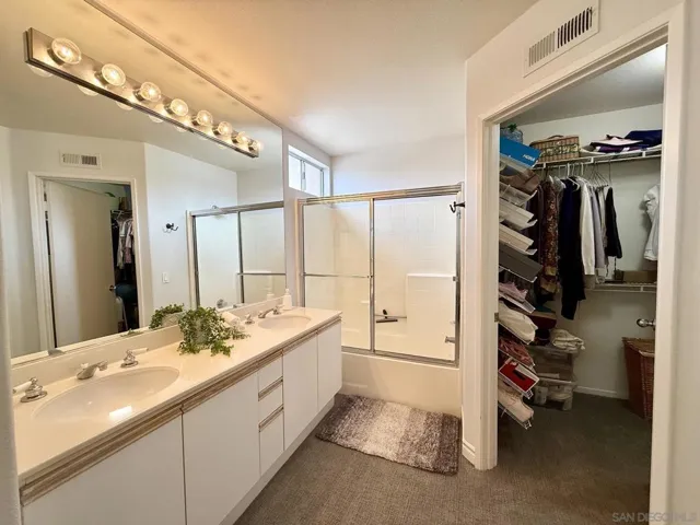 Spacious en suite primary bathroom features double sinks, shower/tub combo, walk-in closet, and separate toilet room.