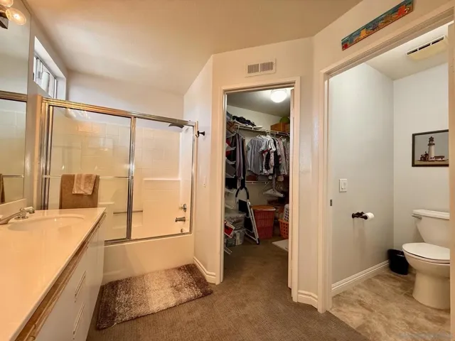 Large en suite primary bathroom with double sinks, walk-in closet, and separate toilet room.