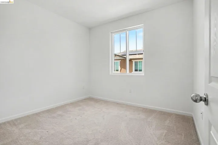 Neutral tone carpet flooring with white baseboards