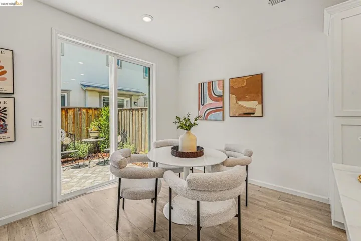 Sliding glass door opening to a private paved patio with a wooden fence surround