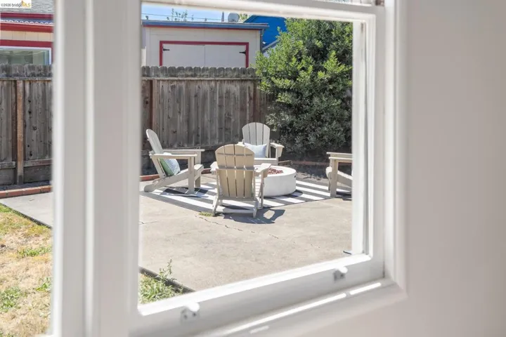 Concrete patio featuring a round fire pit and surrounding perimeter fencing