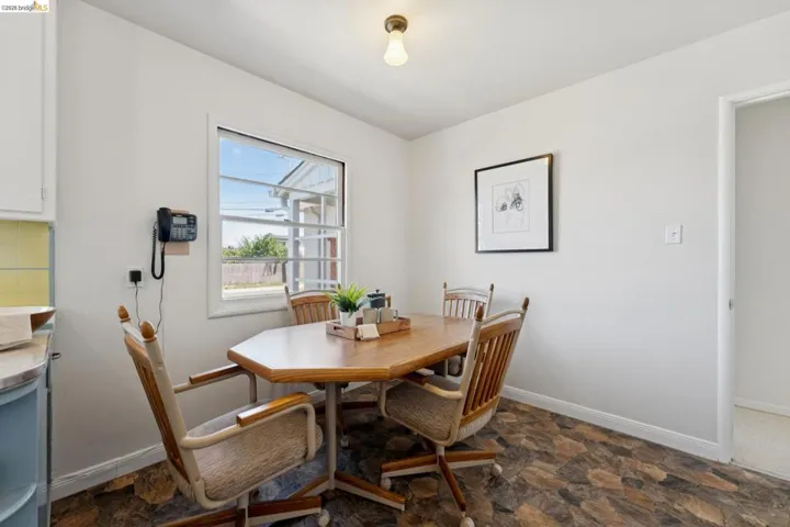 Bright dining space featuring a window, overhead lighting, and mosaic-style flooring