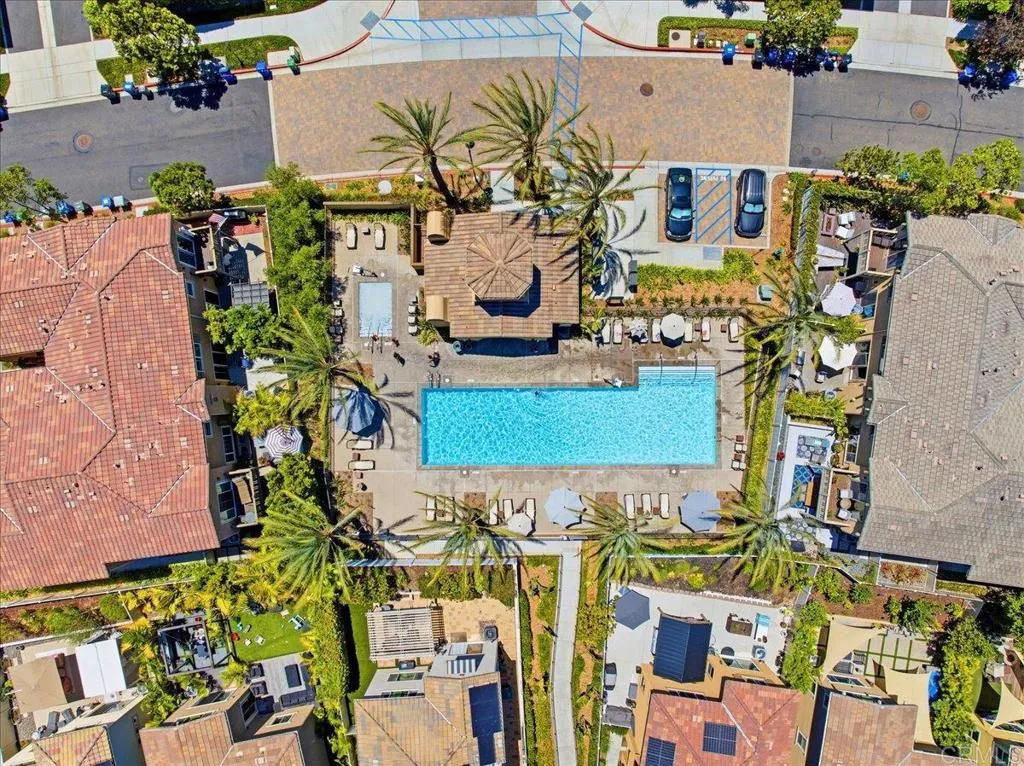 Bird's-eye view of the community pool, clubhouse, and landscaped grounds.