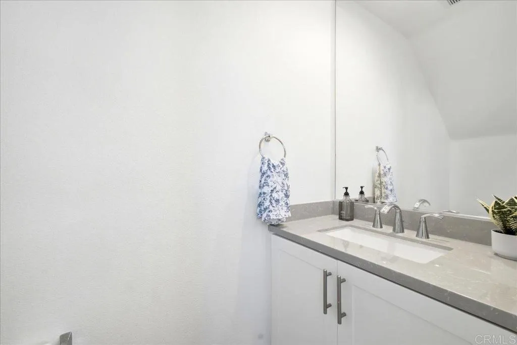 Convenient main-level powder room with a modern vanity and quartz countertop.