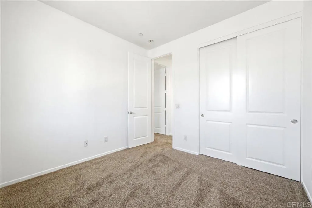 Spacious bedroom with large closet and neutral finishes throughout.