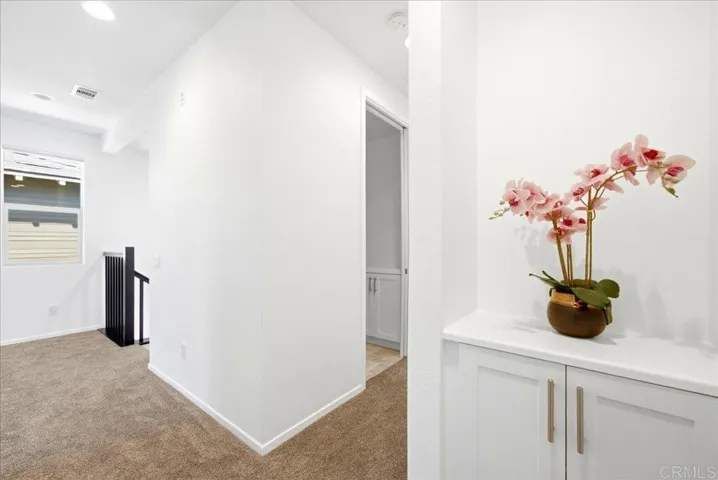 Upstairs hall with built-in storage cabinet for added organization.