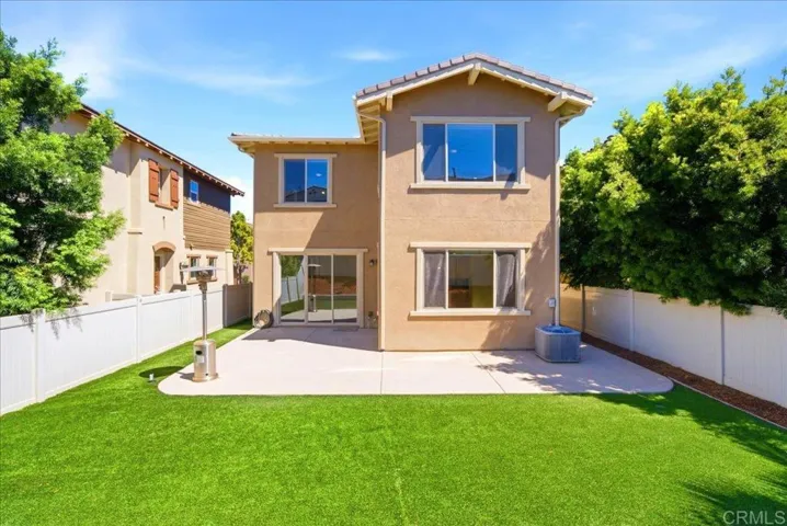 Spacious backyard with turf, patio, and privacy fencing for outdoor enjoyment.