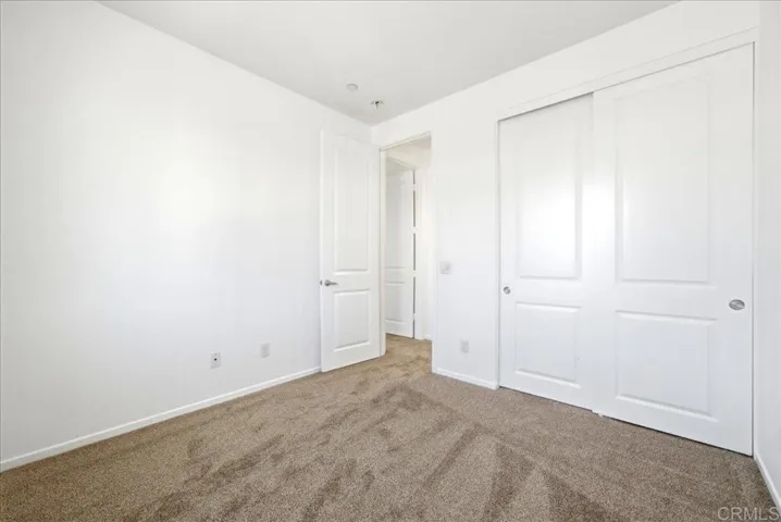 Spacious bedroom with large closet and neutral finishes throughout.