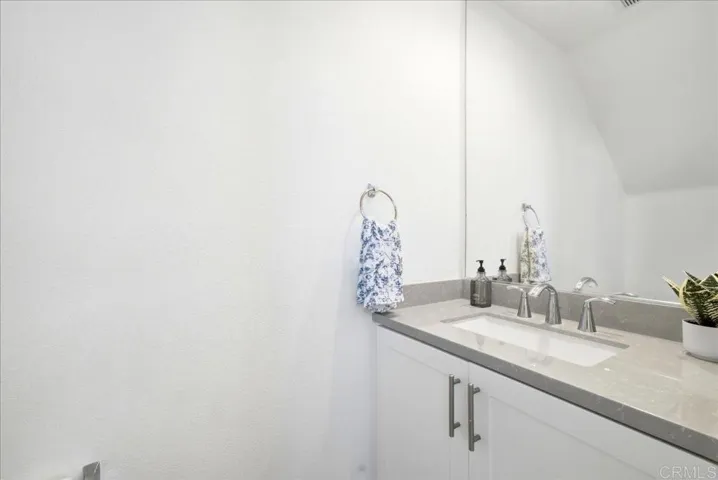 Convenient main-level powder room with a modern vanity and quartz countertop.