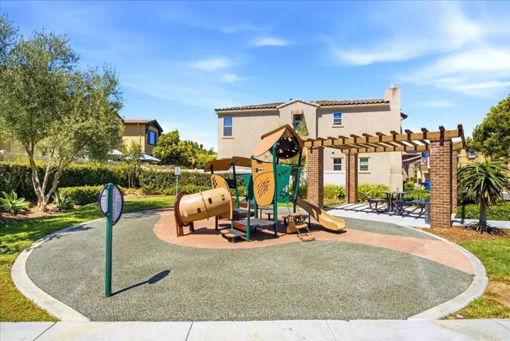 Community playground with shaded seating and green space nearby.