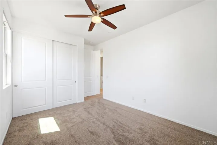 This bedroom has natural light from two windows streaming in and new carpet.