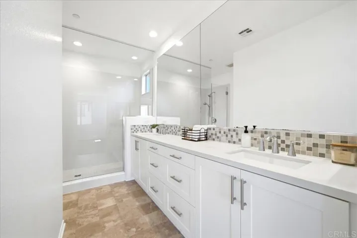 Primary bath with dual sinks, quartz counters, and walk-in shower.