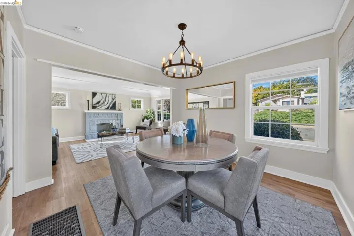 Dining area featuring a circular wood-finish table, a dark bronze chandelier, and wood-finish flooring