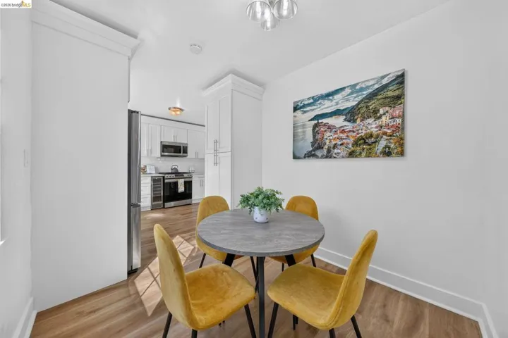 Dining area featuring wood-finish flooring, white walls, and a modern ceiling light fixture