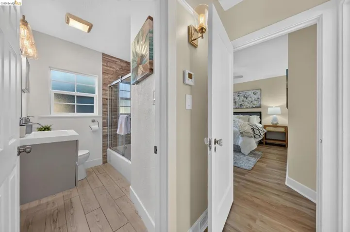 Contemporary bathroom featuring wood-finish tile flooring and a glass-enclosed shower with a wood-plank accent wall