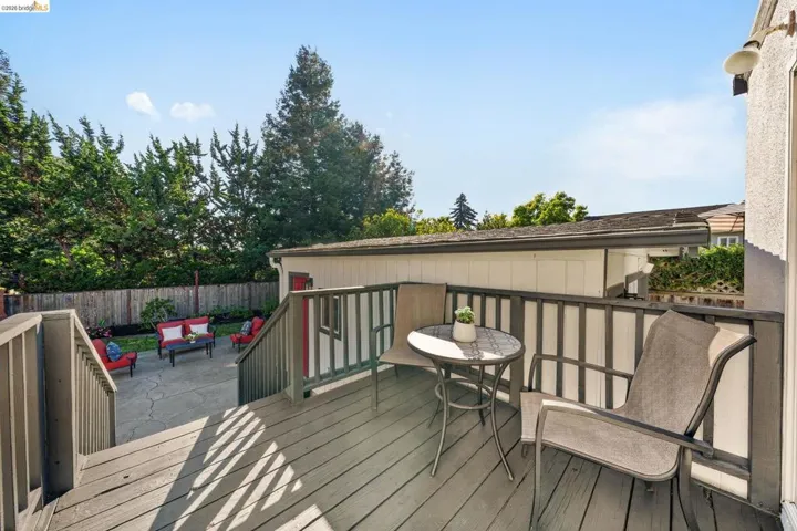 Upper-level wooden deck with a slatted railing system and exterior lighting fixture
