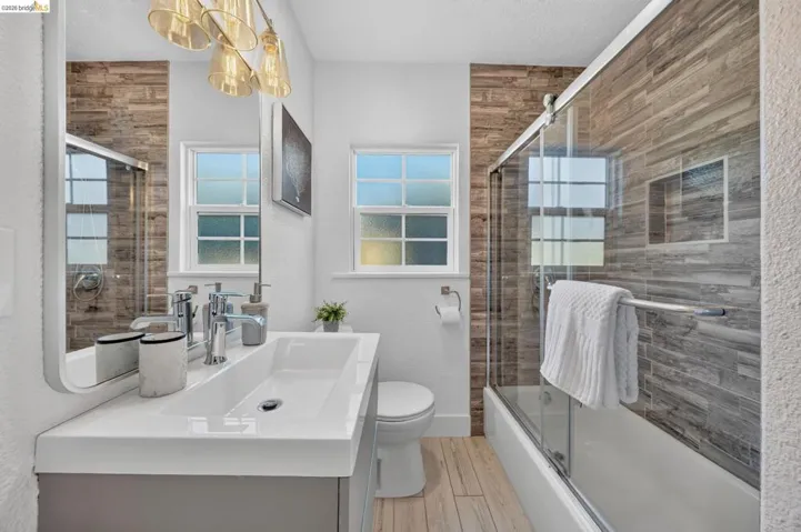 Bathroom featuring a vanity with an integrated rectangular sink, chrome faucet, and a large wall-mounted mirror