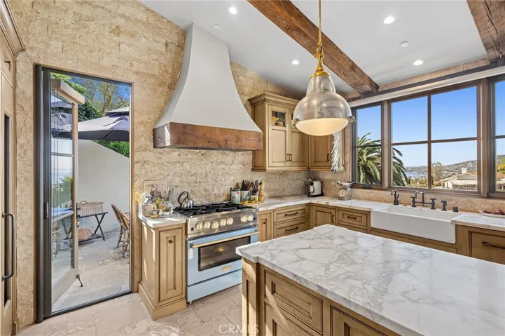 The kitchen opens seamlessly to an ocean-view deck with a built-in BBQ, extending the living and entertaining spaces for both intimate relaxation and open-air gatherings.