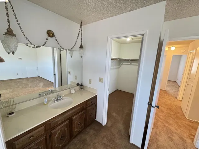 Bathroom vanity featuring a single sink, light-toned countertop, and wood-finish cabinetry